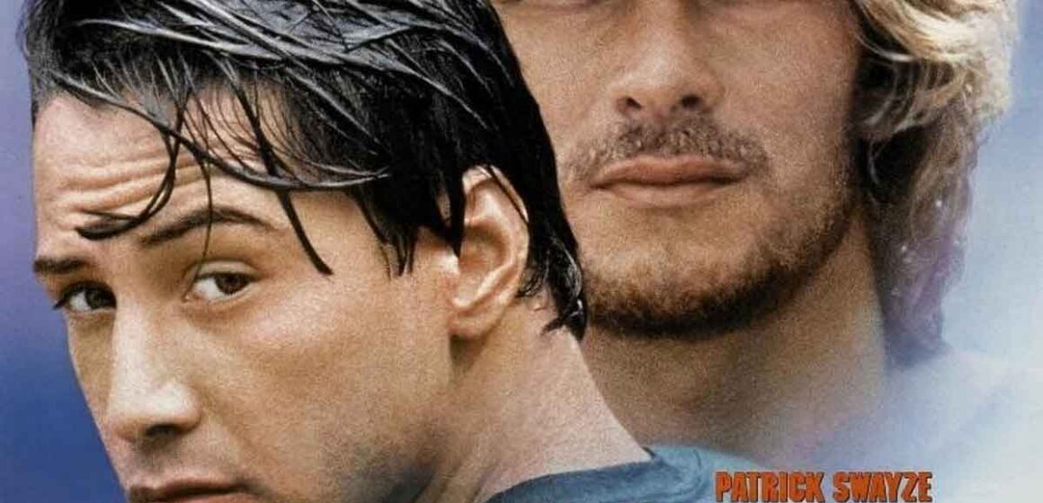 Captura de la película Point Break con Patrick Swayze y Keanu Reeves en la playa.