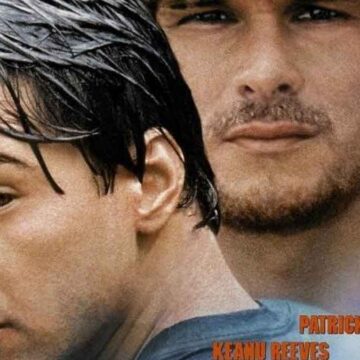 Captura de la película Point Break con Patrick Swayze y Keanu Reeves en la playa.